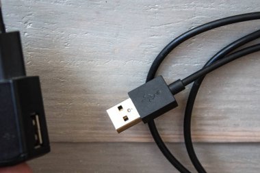 USB kablosu ile şarj ahşap arka plan üzerinde