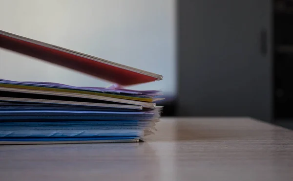 stack of folders with documents on the table