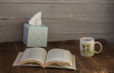 açık bir kitap ve bir kutu peçete ile kafe Kupası