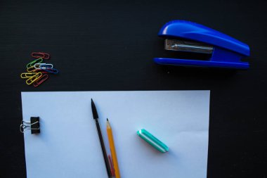 Kağıt ve kalem stepler ve siyah arka plan üzerinde renkli klipleri