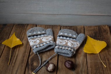 ahşap arka plan üzerinde kestane Mittens sarı yapraklar