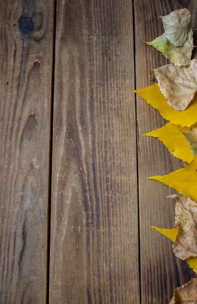 Uno sfondo autunno foglie gialle su sfondo di legno — Foto Stock