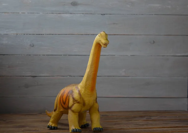 Velký dinosaurus dětská hračka na dřevěné pozadí — Stock fotografie