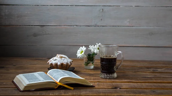 A coffee cupcake flowers and open book on a wooden background — Stock Photo, Image