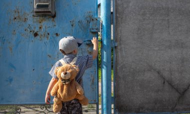 bir sırt çantası ile bahçesinde küçük bir çocuk