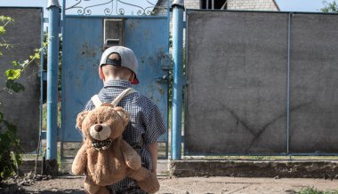 bir şapka gömlek ve bir sırt çantası ile çocuğun bir arka