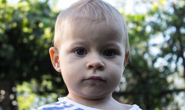 Ağaçların arkasında güzel bir çocuğun portresi.