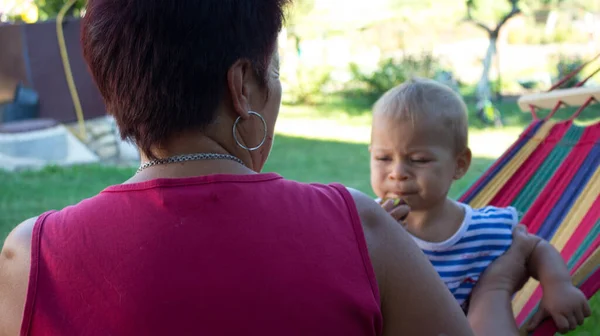 Mała dziewczynka grimace na hamaku z babcią — Zdjęcie stockowe