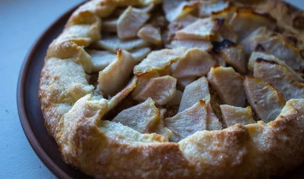 Яблочный пирог на глиняной тарелке на белом фоне — стоковое фото