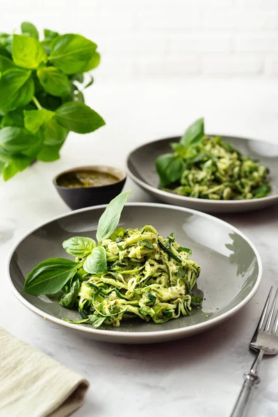 Zucchini vegan pasta in two plates on white background. Vegetarian healthy food