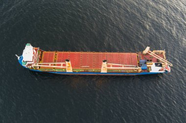 Karanlık Baltık Denizi 'nde yelken açan vinçleri olan büyük bir kargo gemisinin yukarıdan aşağıya insansız hava aracı görüntüsü.