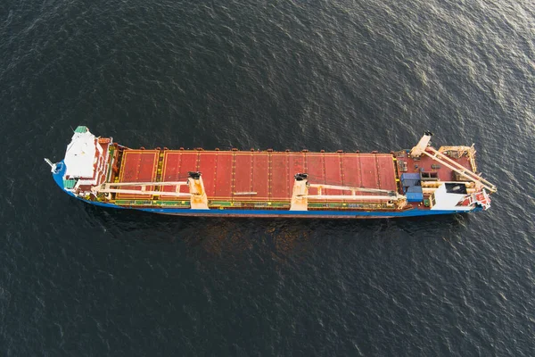 Karanlık Baltık Denizi 'nde yelken açan vinçleri olan büyük bir kargo gemisinin yukarıdan aşağıya insansız hava aracı görüntüsü.