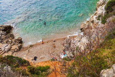 Saint-Jean-Cap-Ferrat, French Riviera, Fransa 'da gözlerden uzak bir kumsalda dinlenen insanların yüksek açılı görüntüsü.