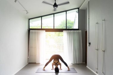 Asyalı Genç kadın pratik yoga gri arka planda. Gençler yoga kapalı yapmak.