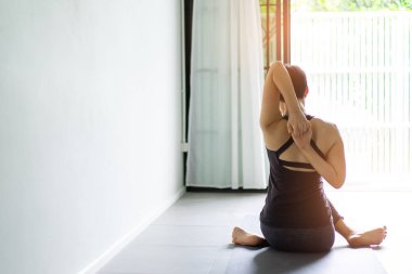 Genç kadın pratik yoga gri arka planda. Gençler yoga kapalı yapmak.
