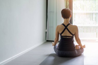 Genç kadın pratik yoga gri arka planda. Gençler yoga kapalı yapıyor. El jest meditasyon içinde kapatın. Kopya alanı.