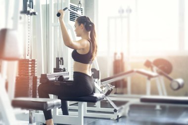 Güzel vücutlu kaslı genç bir kadın halterle egzersiz yapıyor. Sportif kız spor salonunda ağırlık kaldırıyor..