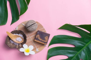 Aromaterapi ürün Spa seti, düz yatıyordu kompozisyon. Tropikal yaprak kavram tarzı., pembe bir arka plan ile masaj. üstten görünüm. Monstera yapraklar şablonu, tropikal yaz moda arka plan.