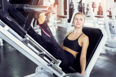 Güzel vücutlu kaslı genç bir kadın halterle egzersiz yapıyor. Sportif kız spor salonunda ağırlık kaldırıyor..
