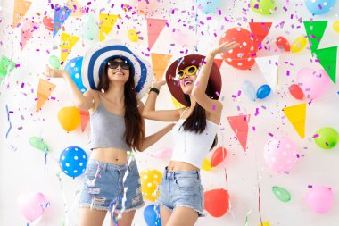 Asyalı Genç kadın ve mutlu, komik concept.drinking şarap mutlu ve eğlenceli yeni yılda kutlamak, renk balon arka plan konfeti kutlama yeni yıl veya Doğum günü parti Grup.