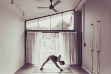 Genç kadın pratik yoga gri arka planda. Gençler yoga kapalı yapıyor. Güzel genç fitness kadının çalışma dışarı üstten görünüm .