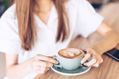Bir kafede kahve içen kadın . Asyalı kadının gülümseyen portresi
