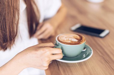 Bir kafede kahve içen kadın . Asyalı kadının gülümseyen portresi