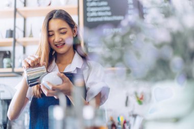 Kafeteryada kollarını kollar halinde duran genç asyalı garson. C
