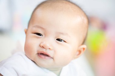 Odada Asyalı bebek mutlu. Asya bebek kız yatarken aşağı üzerinde yatak .