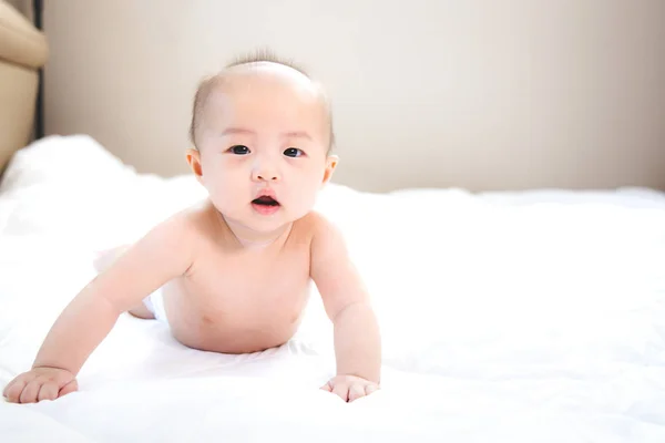 Asiática bebé feliz en la habitación.Asiática bebé niña acostada en la cama  . — Foto de Stock