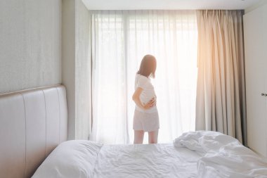 Uyanmak sonra yatakta uzanan kadın, arka görünüm. Kadın sittin