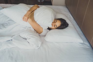 Uyanmak sonra yatakta uzanan kadın, arka görünüm. Kadın sittin