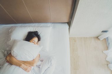 Uyanmak sonra yatakta uzanan kadın, arka görünüm. Kadın sittin