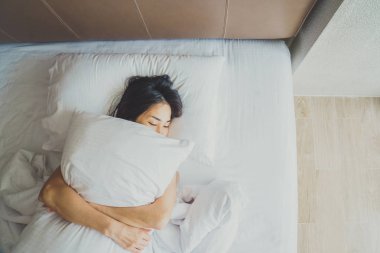 Uyanmak sonra yatakta uzanan kadın, arka görünüm. Kadın sittin