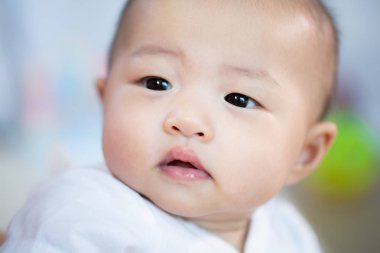 Odada Asyalı bebek mutlu. Asya bebek kız yatarken aşağı üzerinde yatak .