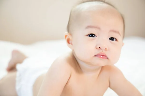 Asiática bebé feliz en la habitación.Asiática bebé niña acostada en la cama  . — Foto de Stock
