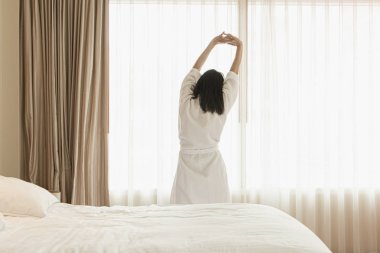 Uyanmak sonra yatakta uzanan kadın, arka görünüm. Kadın sittin