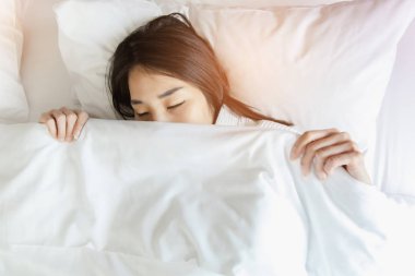 Uyanmak sonra yatakta uzanan kadın, arka görünüm. Kadın sittin