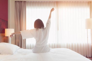 Uyanmak sonra yatakta uzanan kadın, arka görünüm. Kadın sittin