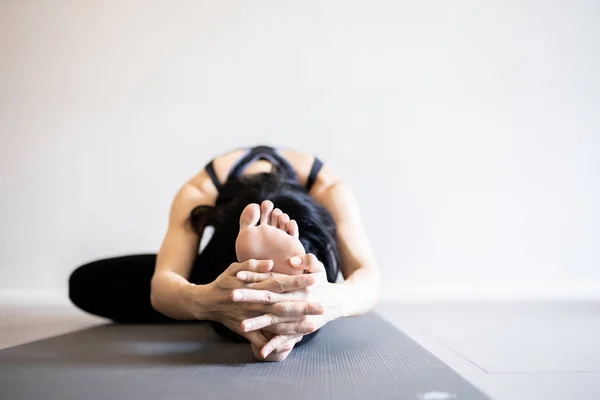 Junge Frau praktiziert Yoga im grauen Hintergrund. — Stockfoto