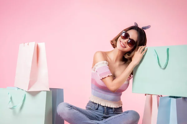 Mujer joven bonita asiática sentada sobre fondo pastel rosa. Ella... — Foto de Stock