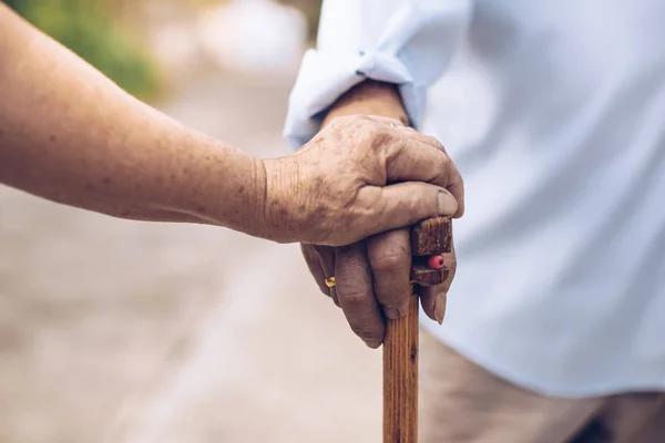 Primer plano de las manos ancianas en las arrugas sosteniendo caminar stick.elde — Foto de Stock