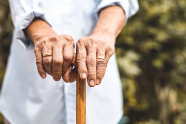 Baston tutan kırışıklıklarda yaşlı ellerin yakınlığı.elde