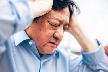 Baş ağrısı olan yaşlı bir adamın portresi.