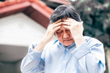 Baş ağrısı olan yaşlı bir adamın portresi.