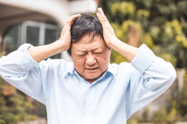 Baş ağrısı olan yaşlı bir adamın portresi.