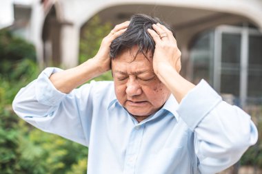 Baş ağrısı olan yaşlı bir adamın portresi.