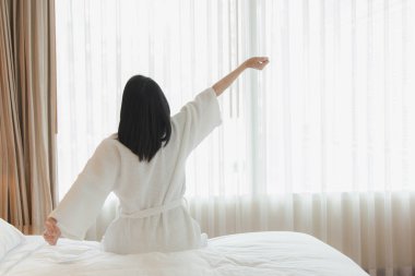 Uyanmak sonra yatakta uzanan kadın, arka görünüm. Kadın sittin