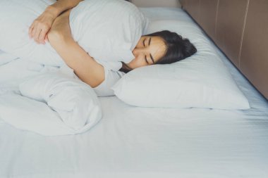 Uyanmak sonra yatakta uzanan kadın, arka görünüm. Kadın sittin