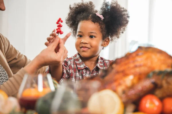 Thanksgiving Celebration Tradition Family Dinner Concept.family having holiday dinner and cutting turkey.Young black adult woman and her daughter happy.